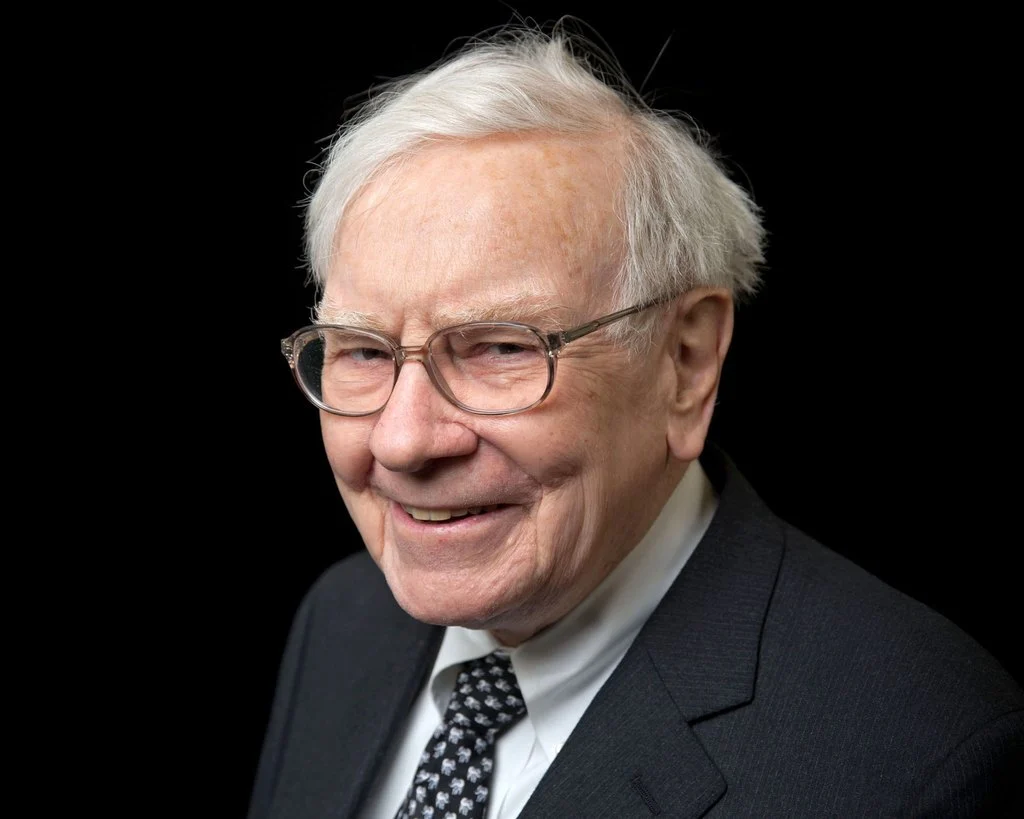 Warren Buffett mặc vest sẫm, chụp trên nền đen