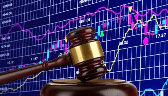 Búa gỗ đặt trên nền biểu đồ nến chứng khoán