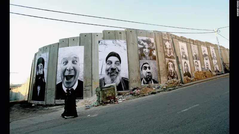 Các bức ảnh chụp người Israel và Palestine này được dán lên bức tường ngăn cách họ tại các vùng đất tranh chấp ở Trung Đông