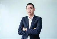 Chân dung người đàn ông mặc vest trước nền xanh nhạt