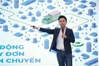 Diễn giả đứng thuyết trình trước màn hình đồ họa về vận chuyển