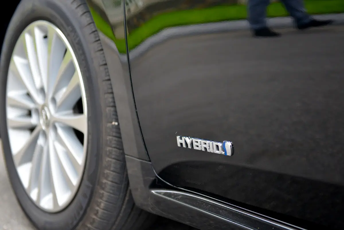 Huy hiệu Hybrid trên thân xe Toyota Avalon, bên cạnh mâm hợp kim