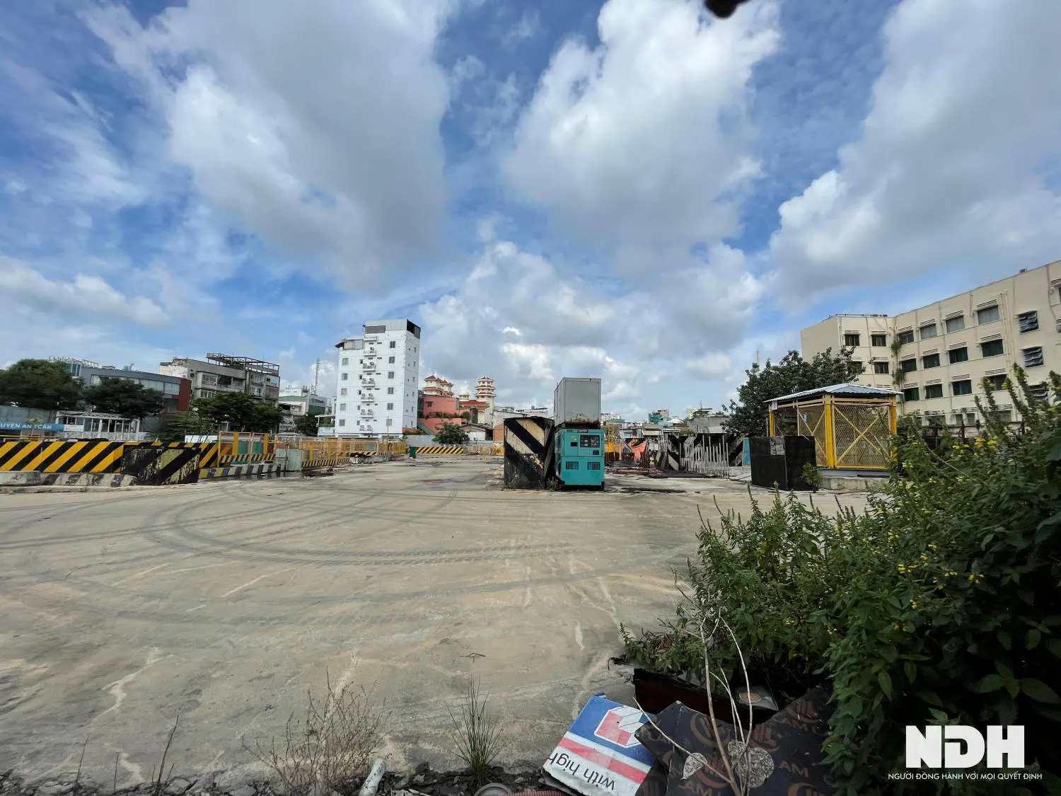 Khu đất trống đã san nền, phía xa là các tòa nhà