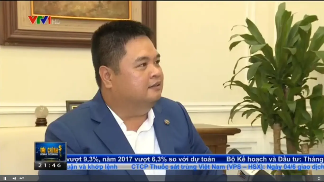 Người đàn ông mặc vest trả lời phỏng vấn trên truyền hình