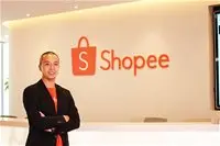 Người đứng khoanh tay trước bảng hiệu Shopee