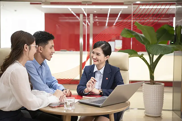 Nhân viên tư vấn trao đổi với hai khách hàng bên bàn làm việc