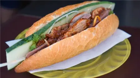 Ổ bánh mì Hội An kẹp thịt và rau thơm bày trên đĩa
