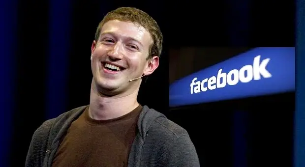 Ông Mark Zuckerberg đứng trước logo Facebook