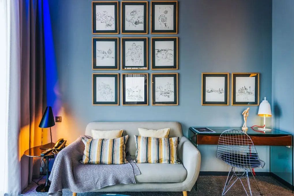Phòng khách sạn CR7 với sofa, bàn làm việc và tranh treo tường