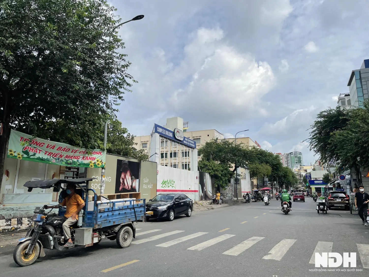 Xe máy chở hàng chạy trên đường trước khu dự án
