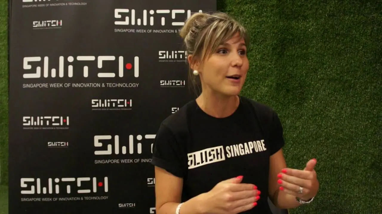 Anna Ratala mặc áo Slush Singapore nói chuyện trước phông sự kiện