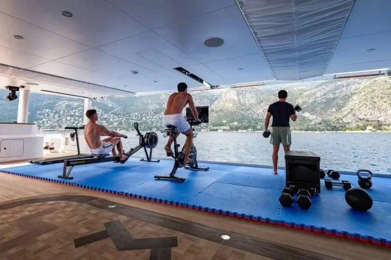 Ba người tập thể dục trong phòng gym nhìn ra biển