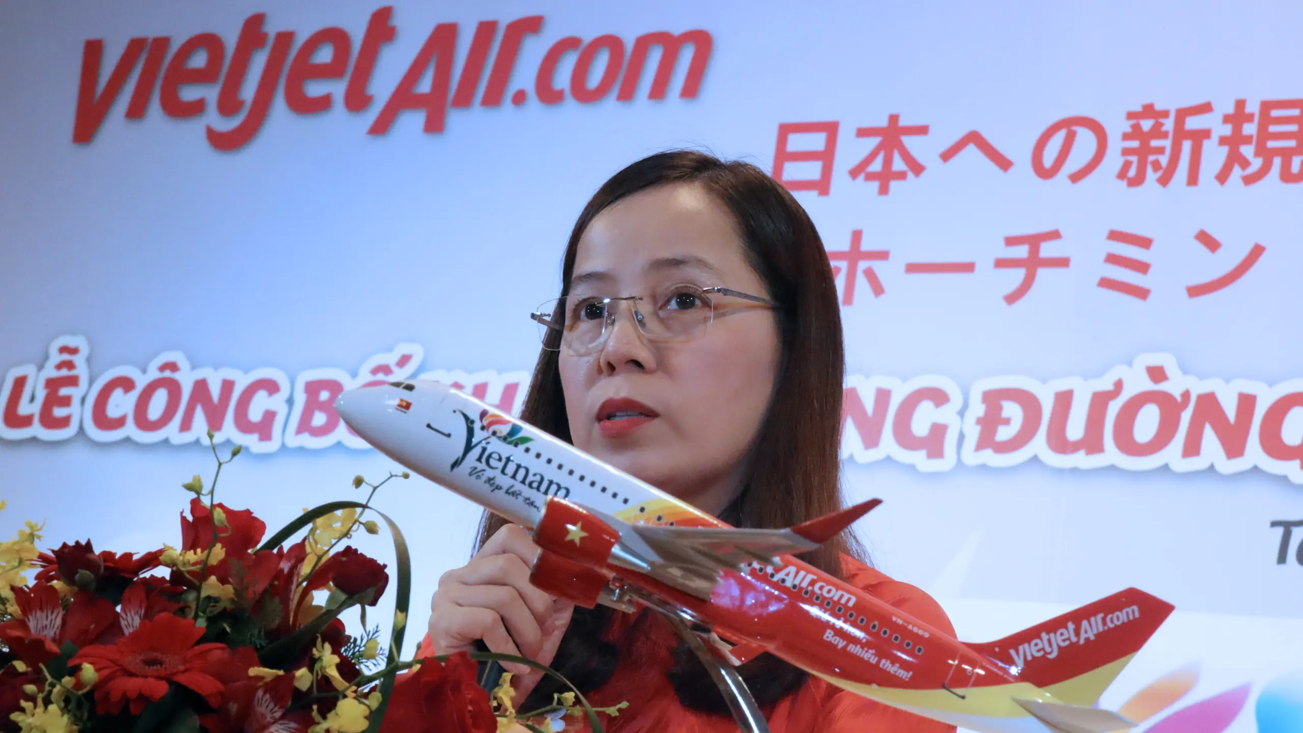 Bà Nguyễn Thị Thúy Bình cầm mô hình máy bay Vietjet tại lễ công bố đường bay