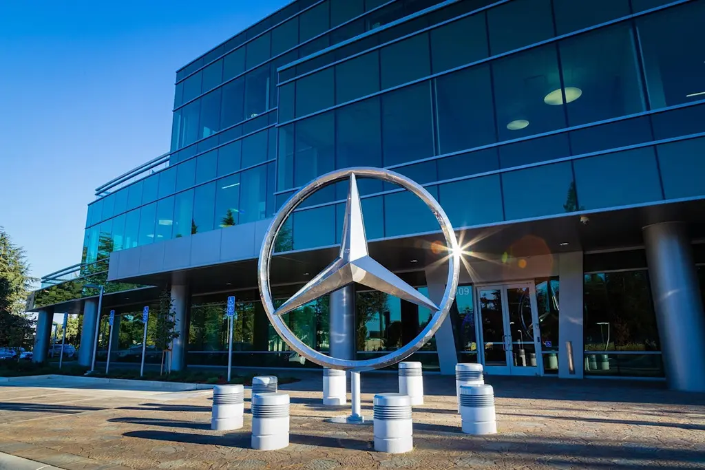 Biểu tượng ngôi sao ba cánh Mercedes-Benz trước tòa nhà kính