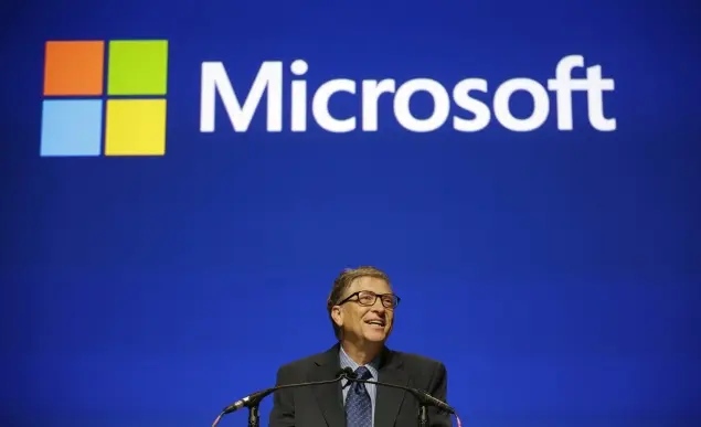 Bill Gates phát biểu trước màn hình logo Microsoft