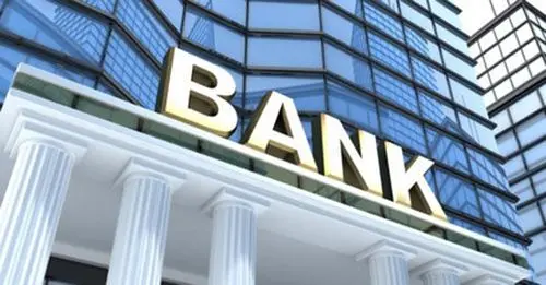 Chữ BANK mạ vàng trên mặt tiền tòa nhà kính có hàng cột trắng