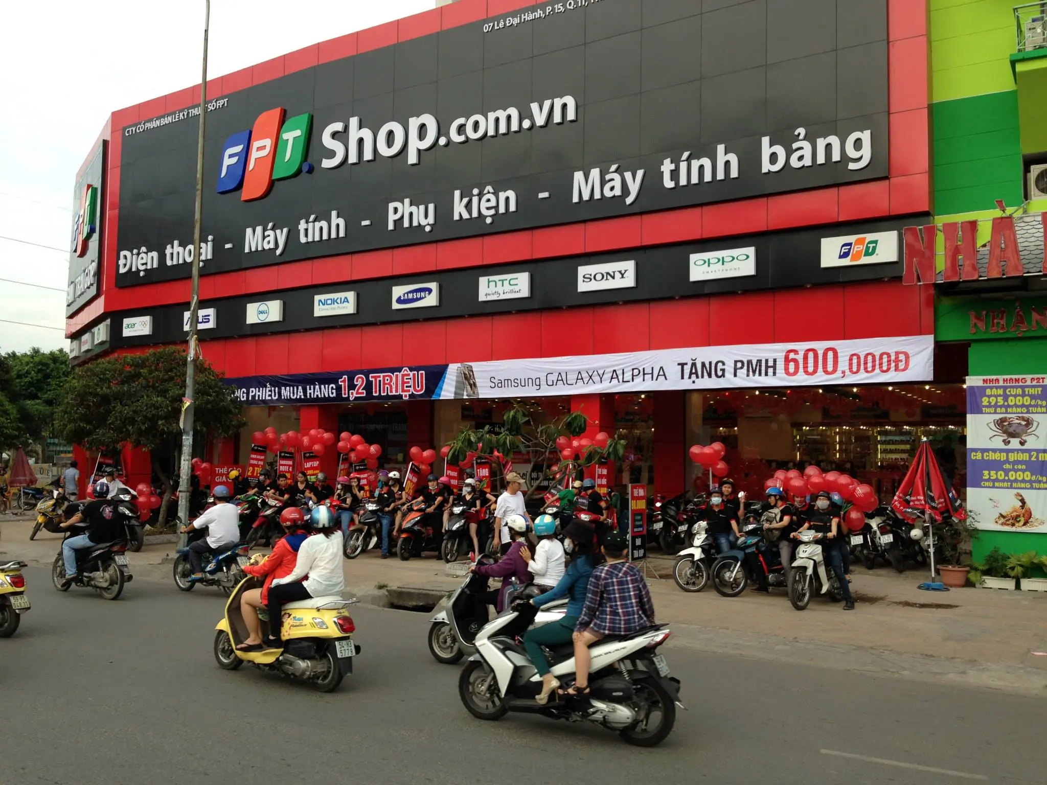 Cửa hàng FPT Shop đông khách, xe máy đỗ kín vỉa hè phía trước