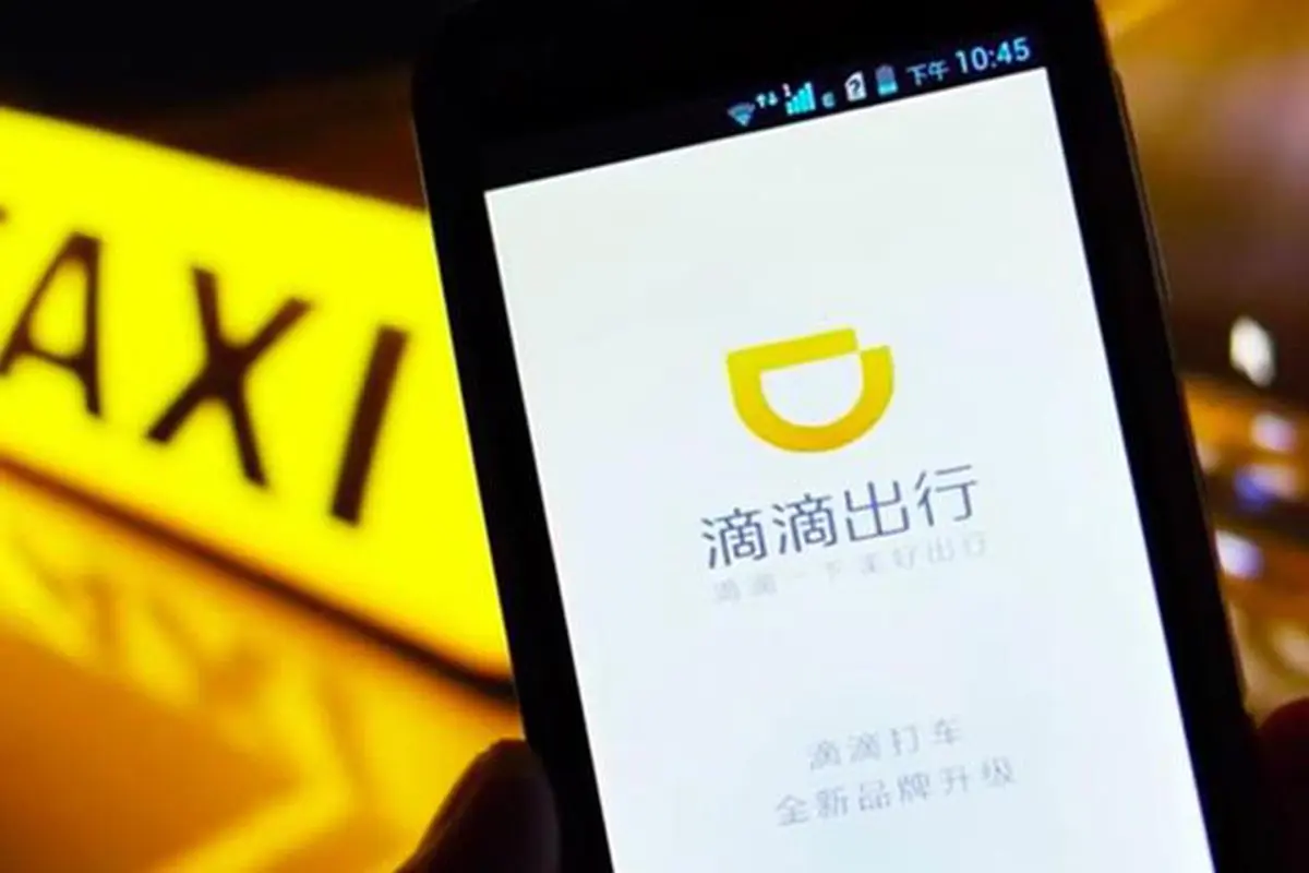 Điện thoại mở ứng dụng Didi Chuxing trước biển taxi