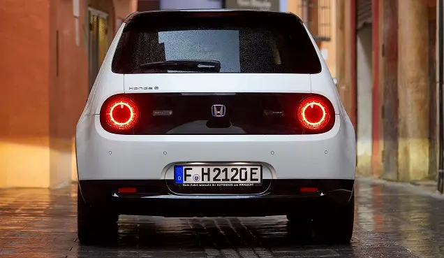 Đuôi xe điện Honda e màu trắng trên phố ướt mưa