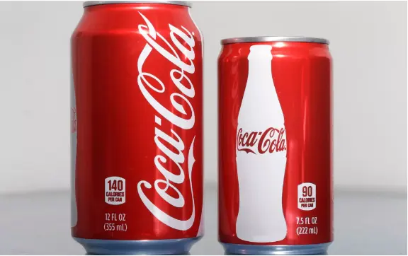 Hai lon Coca-Cola đỏ cỡ lớn và cỡ nhỏ đặt cạnh nhau