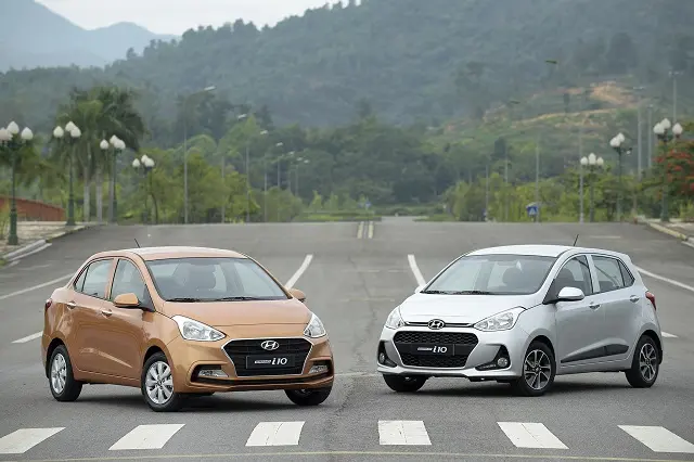 Hai xe Hyundai Grand i10 màu cam và bạc trên đường