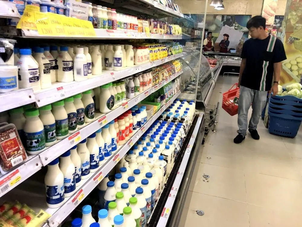 Khách hàng chọn hàng trước quầy sữa trong siêu thị ở Yangon