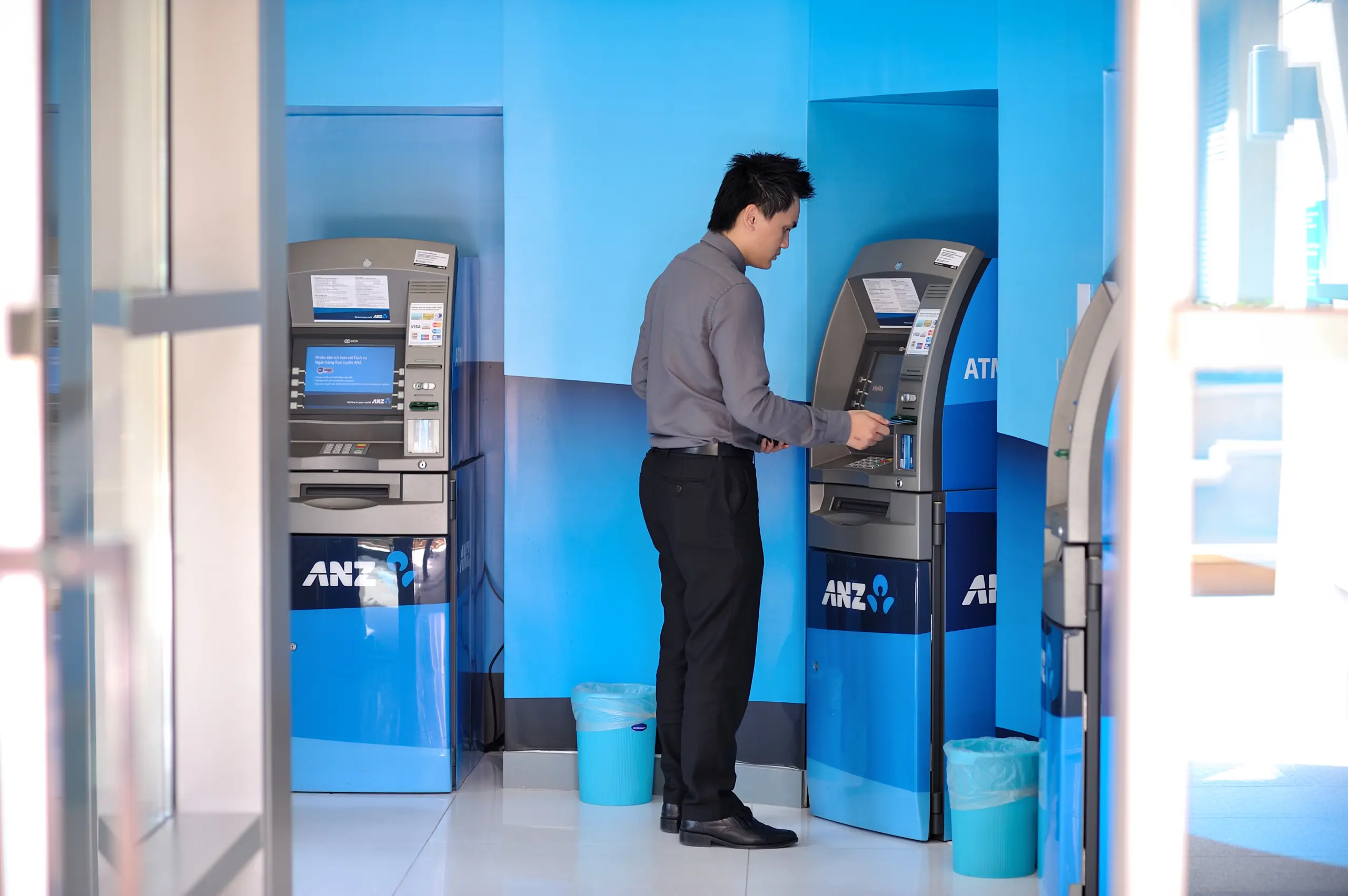 Khách hàng nam rút tiền tại cây ATM của ngân hàng ANZ
