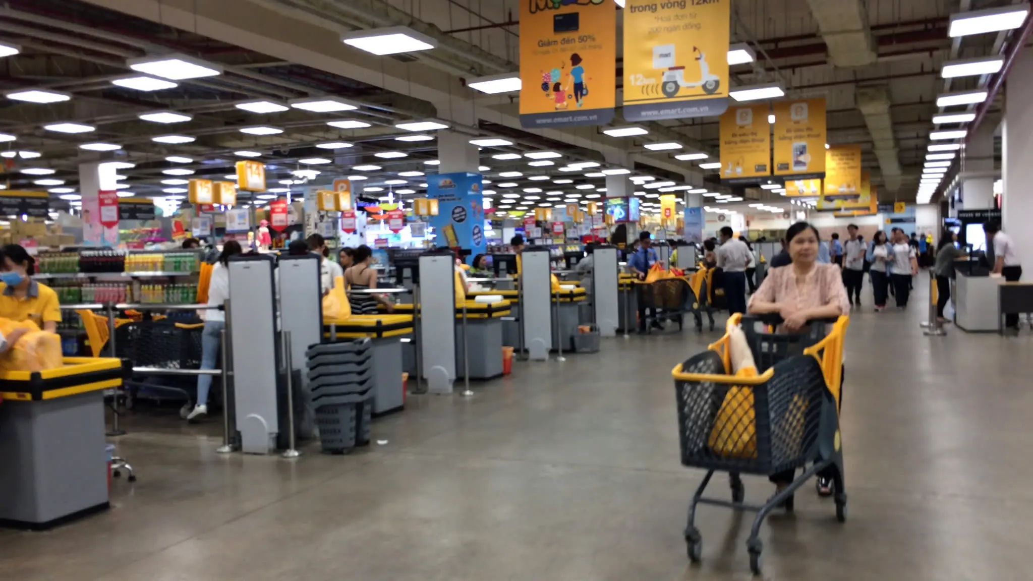 Khu quầy thu ngân siêu thị E-Mart, khách đẩy xe hàng màu vàng