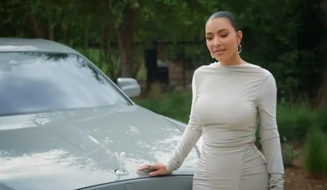 Kim Kardashian chạm tay vào biểu tượng trên nắp capo xe