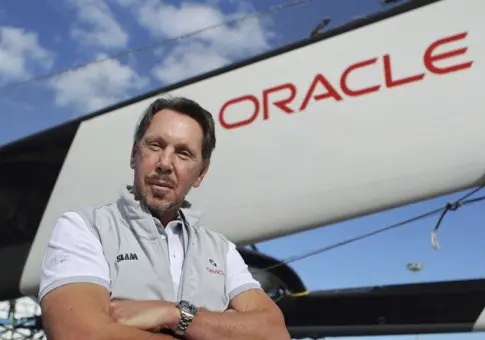 Larry Ellison khoanh tay đứng trước cánh buồm in chữ Oracle