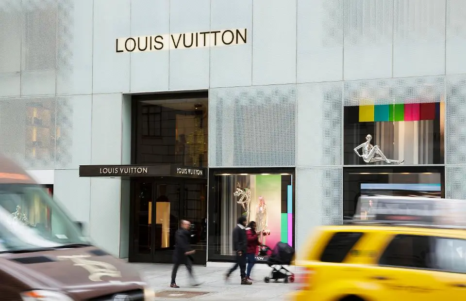 Mặt tiền cửa hàng Louis Vuitton trên phố có taxi vàng chạy qua