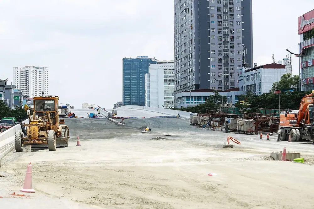 Máy móc thi công trên mặt đường dẫn lên cầu
