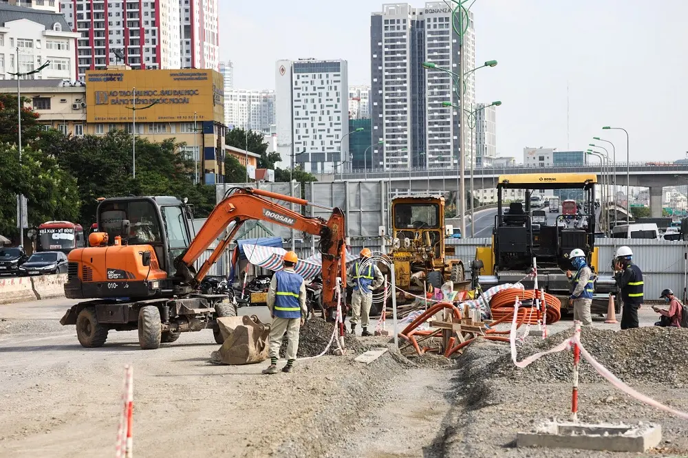 Máy xúc và công nhân thi công chân cầu