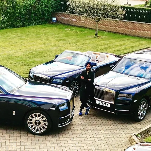 Người đàn ông đứng giữa ba xe Rolls-Royce trên sân