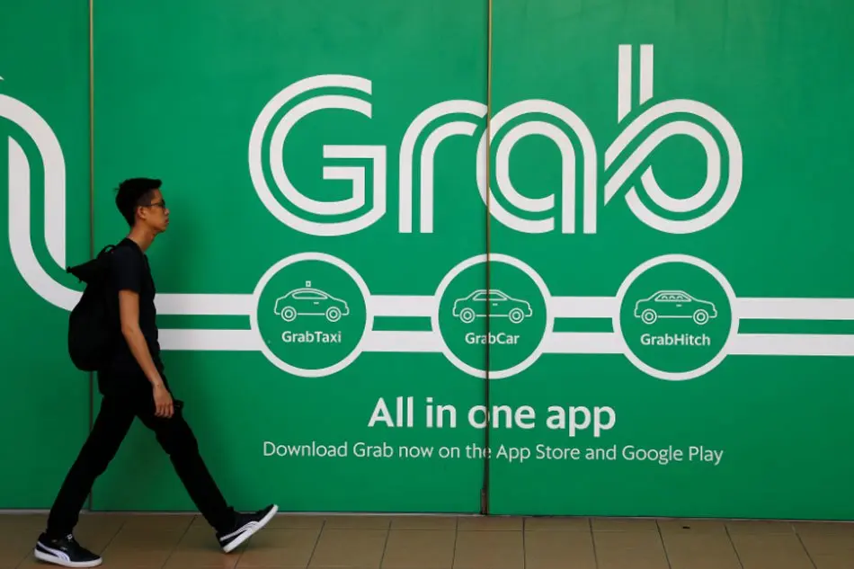 Người đi bộ ngang bức tường quảng cáo Grab All in one app