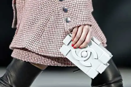Người mẫu cầm túi xách Chanel màu trắng trên sàn diễn