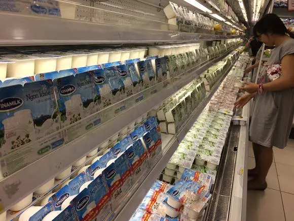 Người mua chọn sữa Vinamilk trên quầy kệ siêu thị