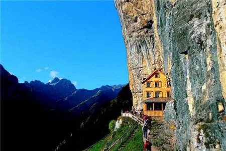 Nhà hàng gỗ nằm sát vách đá dưới bầu trời xanh