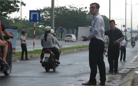 Nhân viên tiếp thị cầm tờ rơi bất động sản mời chào người đi đường