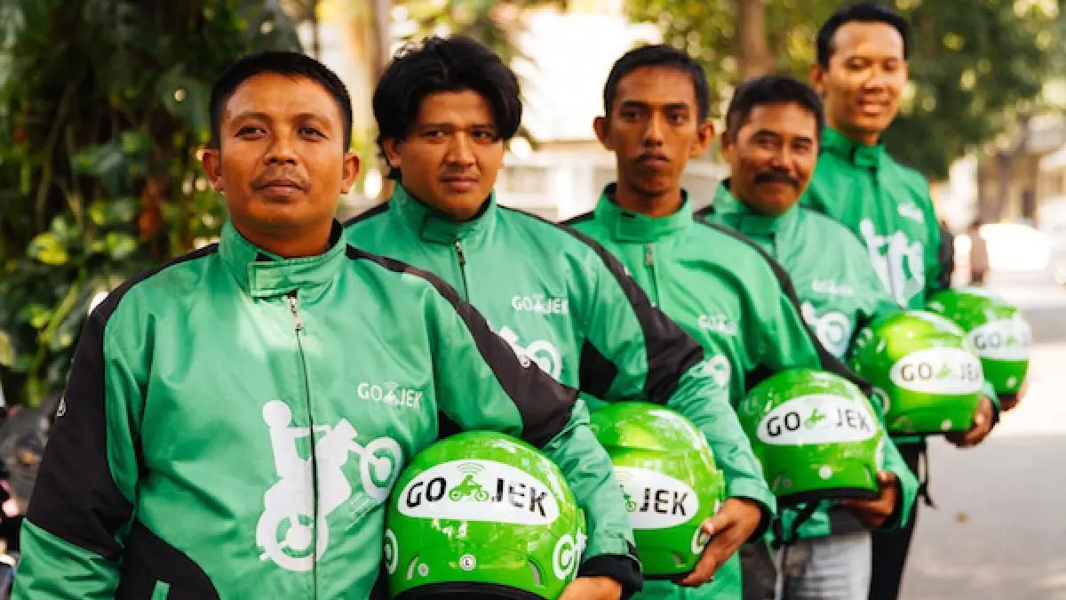 Nhóm tài xế Go-Jek mặc áo khoác xanh cầm mũ bảo hiểm