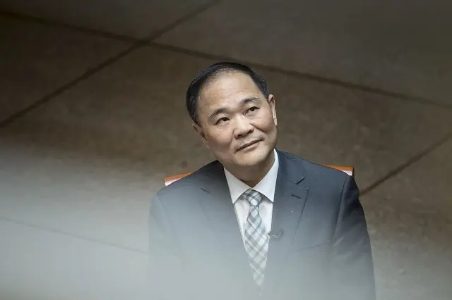 Ông Li Shufu mặc vest ngồi trong phòng