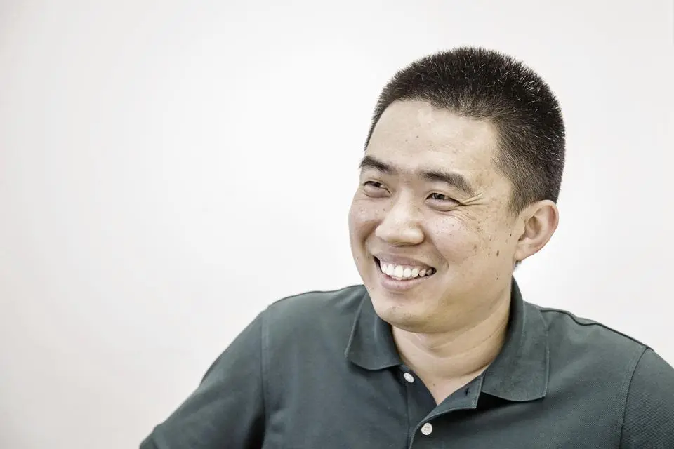 Ông Li Xiang mặc áo polo xanh cười tươi
