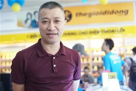 Ông Trần Kinh Doanh mặc áo đỏ sẫm trong cửa hàng Thế Giới Di Động