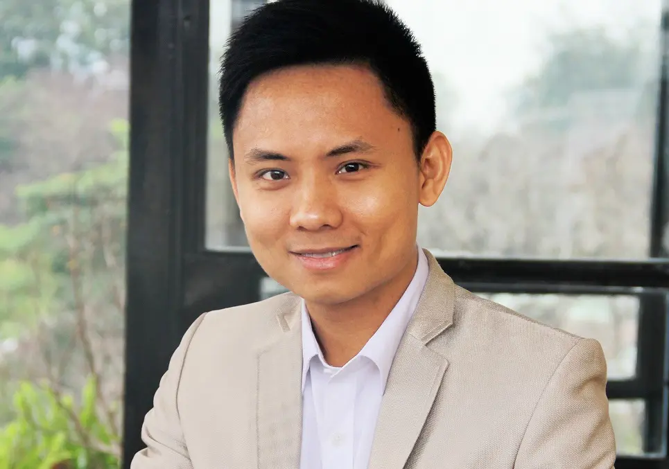 Ông Trần Trọng Tuyến mặc vest màu be, mỉm cười