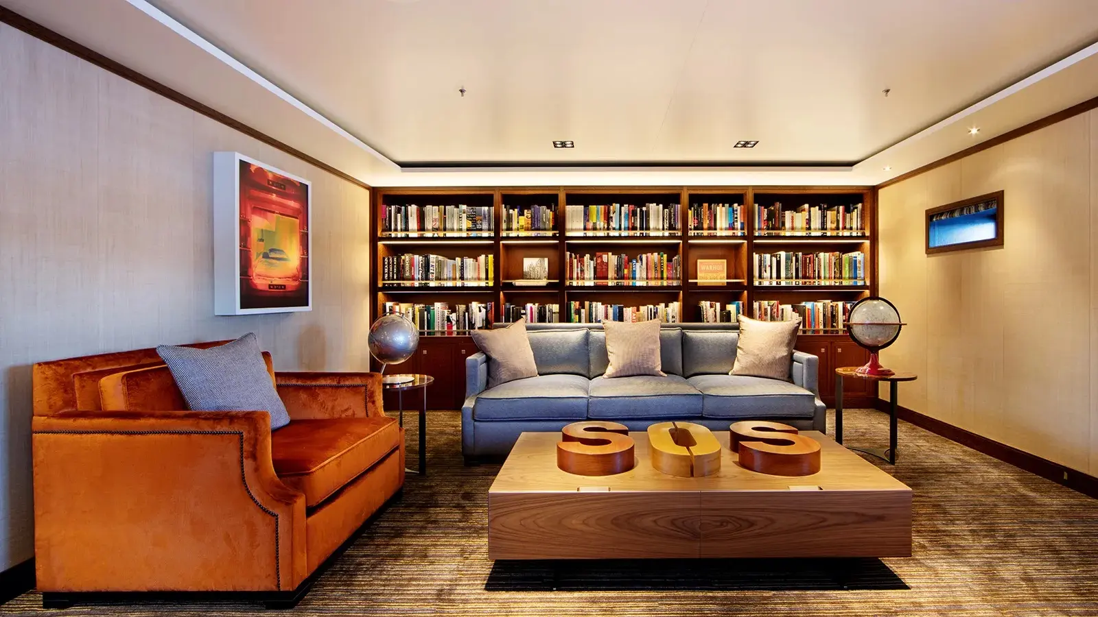 Phòng đọc sách với kệ gỗ cao và sofa