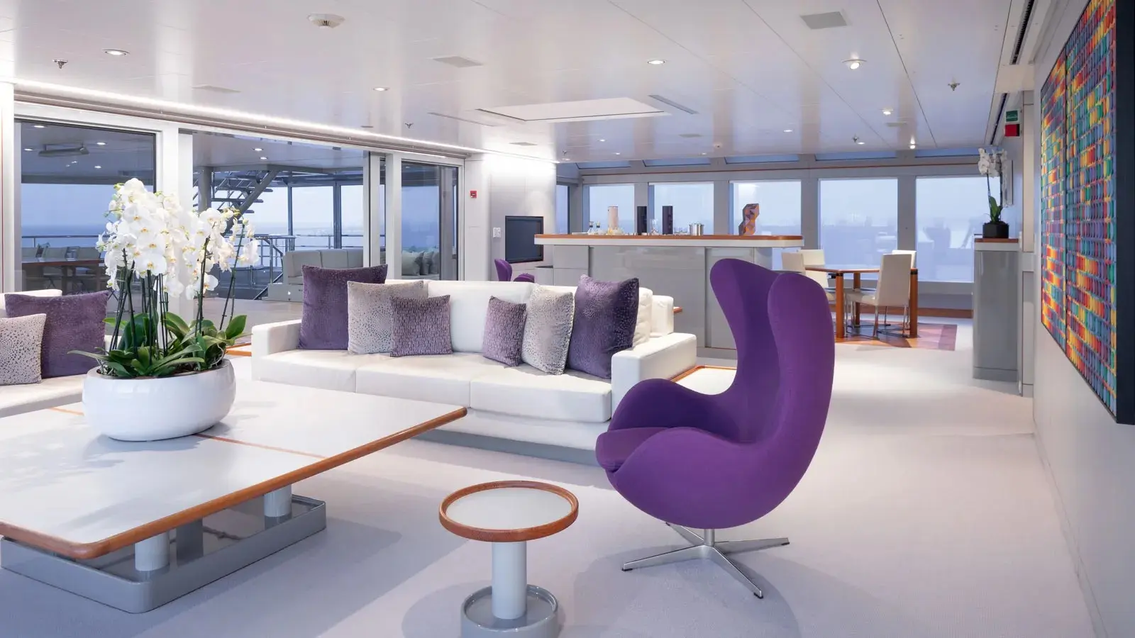 Phòng khách du thuyền với sofa trắng và ghế tím