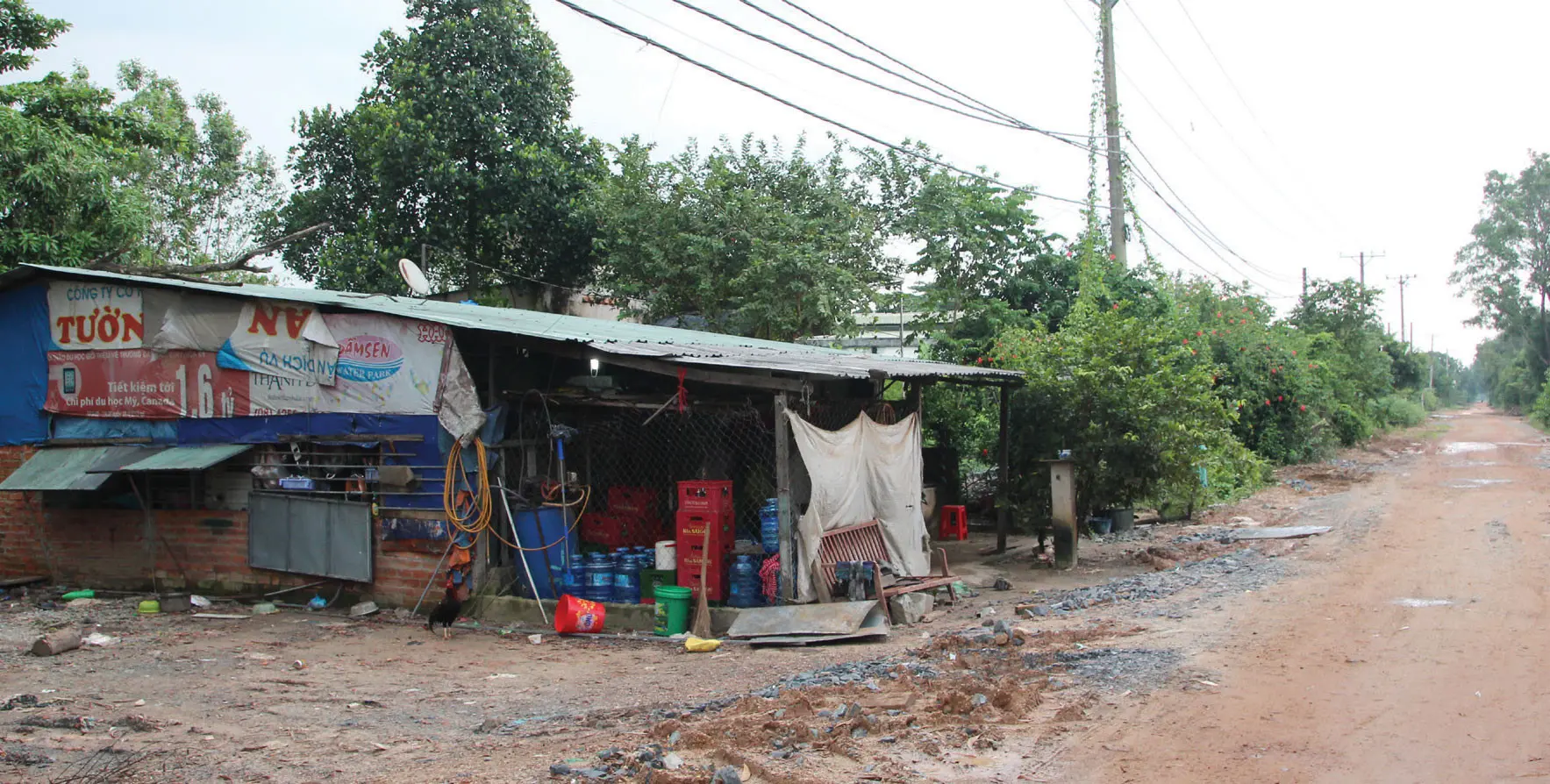 Quán nhỏ bên con đường đất đỏ lầy lội