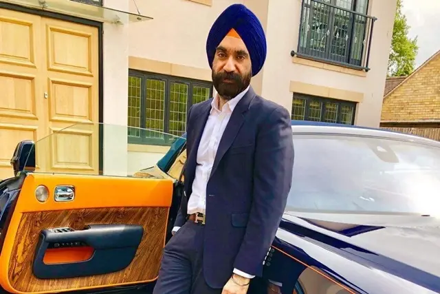 Reuben Singh đội khăn xanh đứng cạnh cửa xe Rolls-Royce