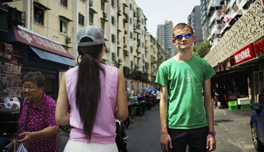 Vitalik Buterin áo xanh lá đứng trên con phố đông người