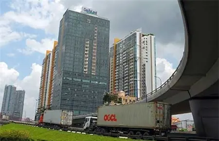 Xe container chạy dưới cầu vượt cạnh các cao ốc văn phòng